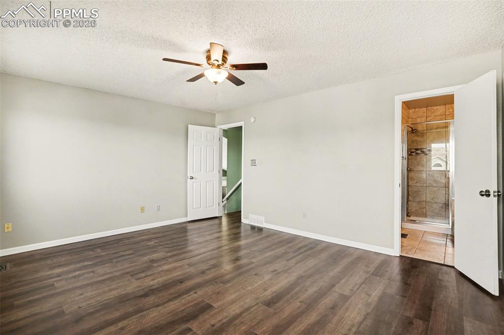 Image 11 of 20: Unfurnished bedroom with a textured ceiling, a ceiling fan, dark wood-style