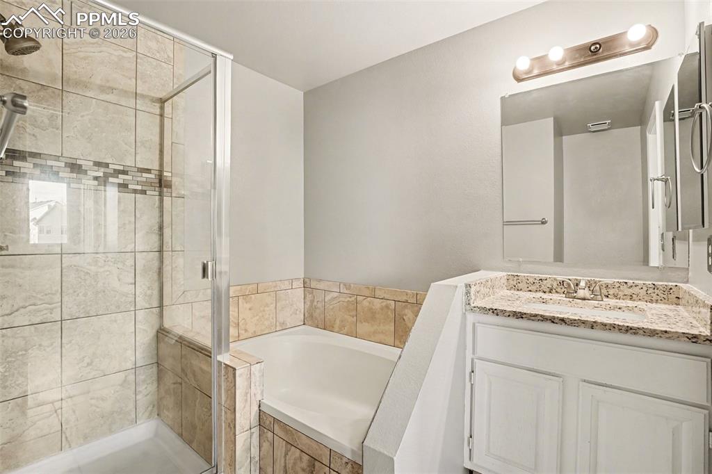 Image 12 of 20: Full bathroom featuring a bath, vanity, and a shower stall