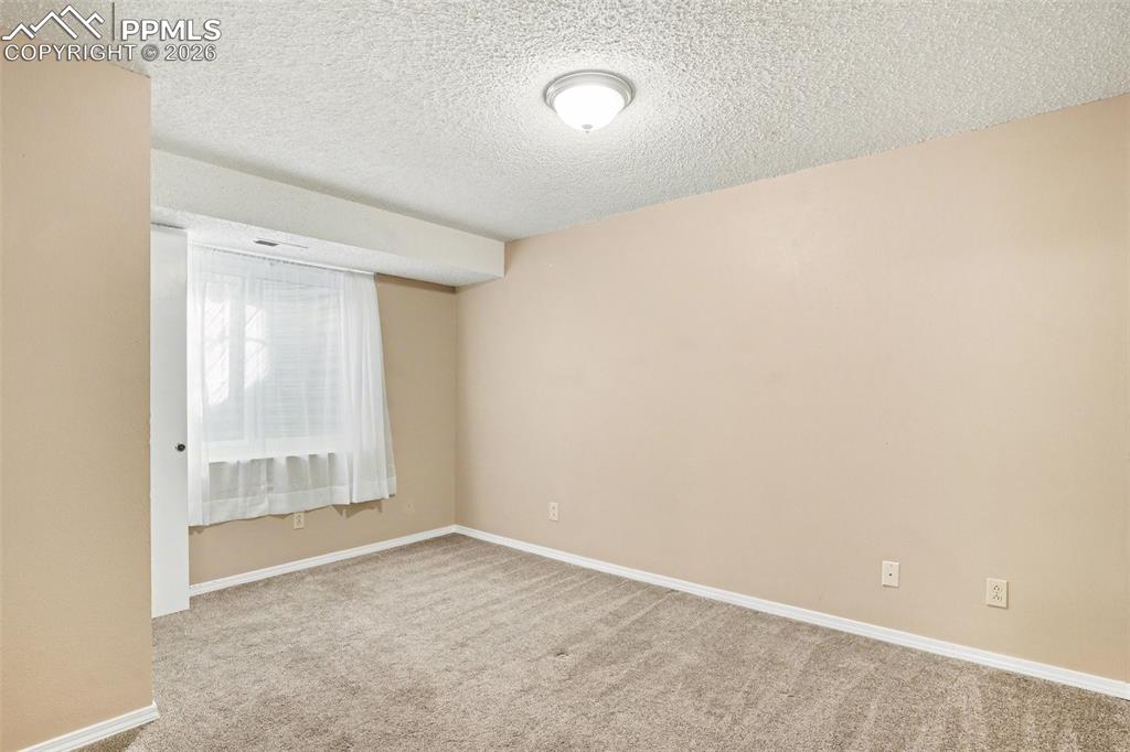 Image 13 of 20: Unfurnished room with light colored carpet and a textured ceiling