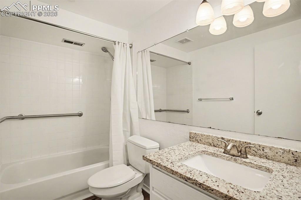 Image 17 of 20: Bathroom featuring shower / bathtub combination with curtain and vanity