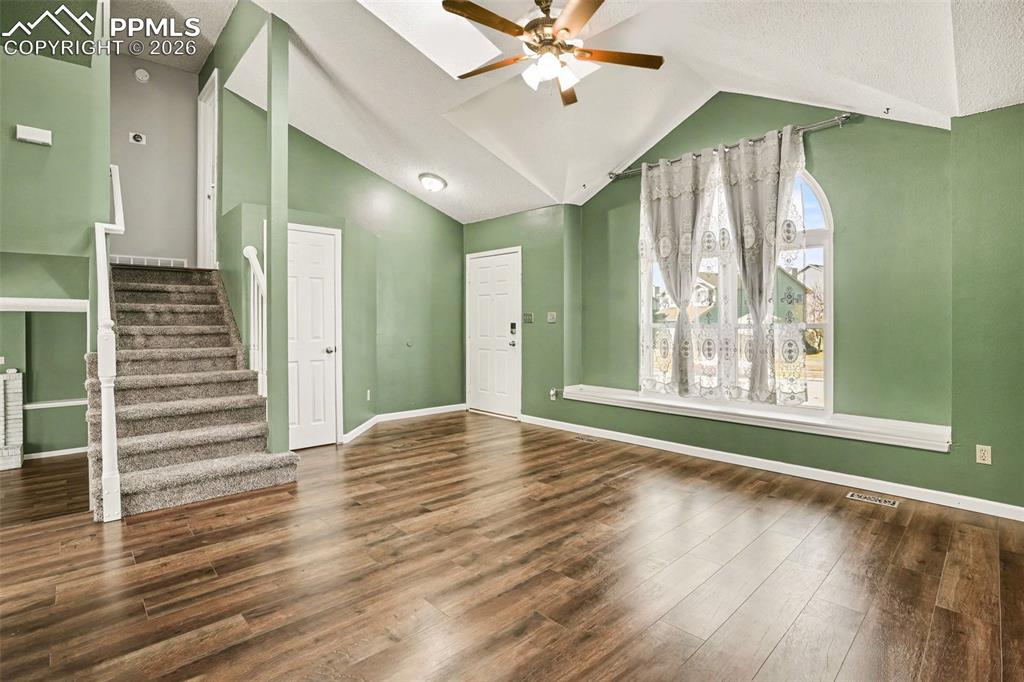Image 3 of 20: Foyer entrance featuring ceiling fan, vaulted ceiling, and dark wood finish
