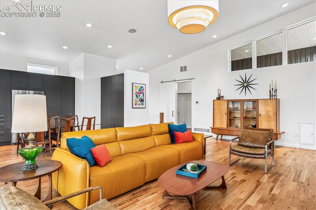 Image 13 of 50: Great room with an open floorplan and solid oak flooring, custom windows &