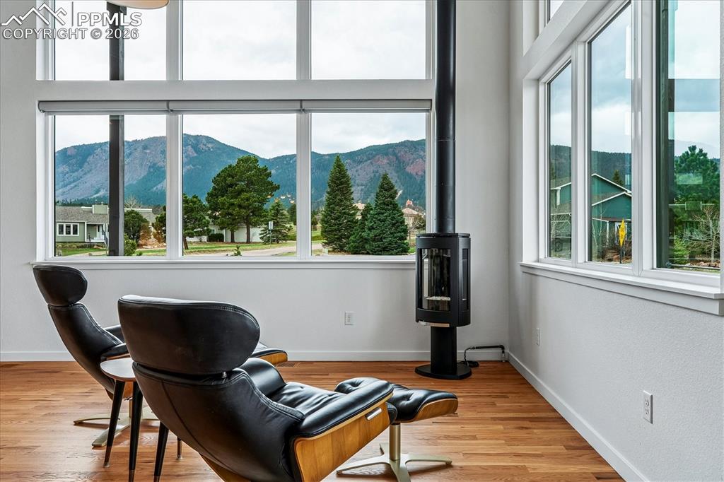 Image 15 of 50: Dining area with solid oak flooring, vaulted ceiling, Jotul cast iron stove