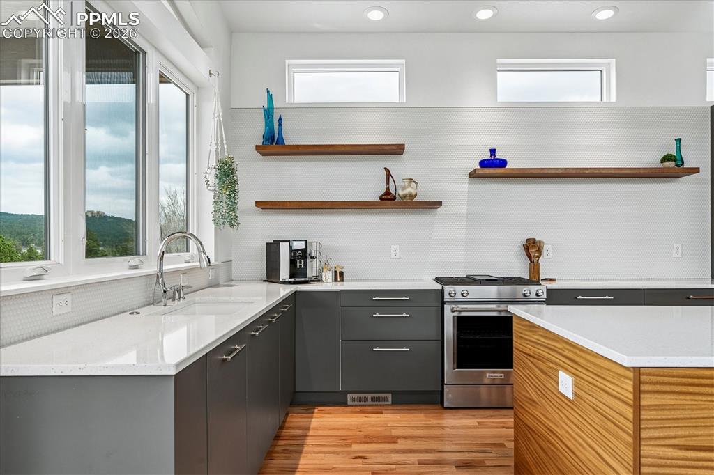 Image 16 of 50: Gourmet kitchen with solid oak flooring, mountain views, designer & recesse