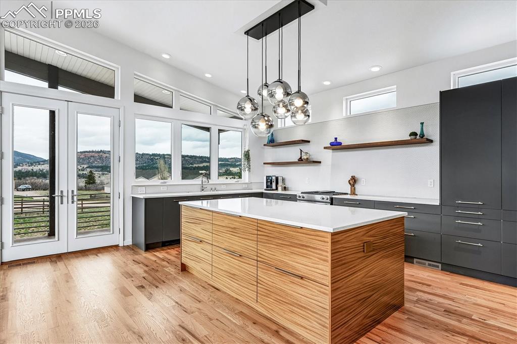 Image 20 of 50: Gourmet kitchen has french door that lead out to the wrap-around porch with