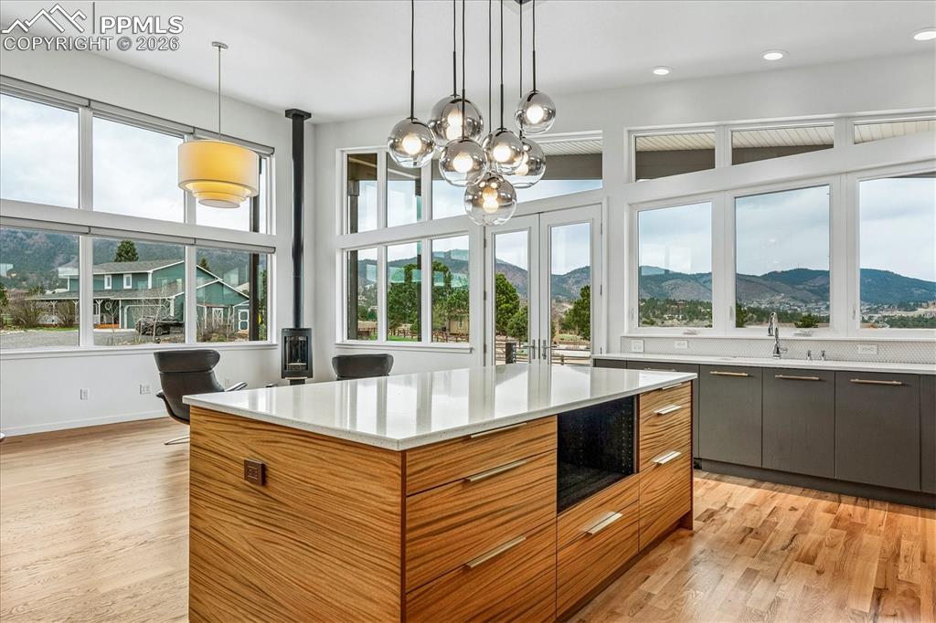 Image 24 of 50: The open layout is surrounded by custom windows, high ceilings and mountain