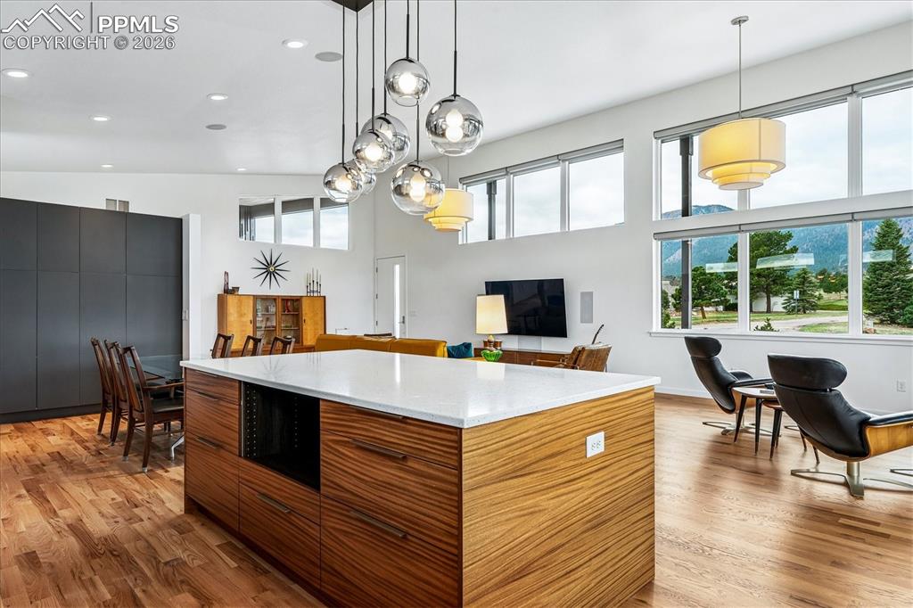 Image 25 of 50: The open layout is surrounded by custom windows, high ceilings and mountain