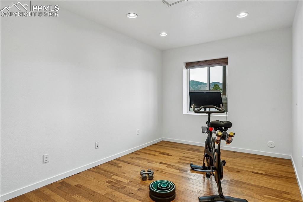 Image 33 of 50: Office or workout room with solid oak flooring, recessed lighting, and larg