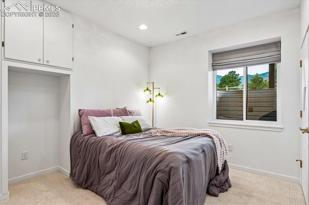 Image 36 of 50: Basement bedroom with new carpet, chandelier, recessed lighting, storage ca