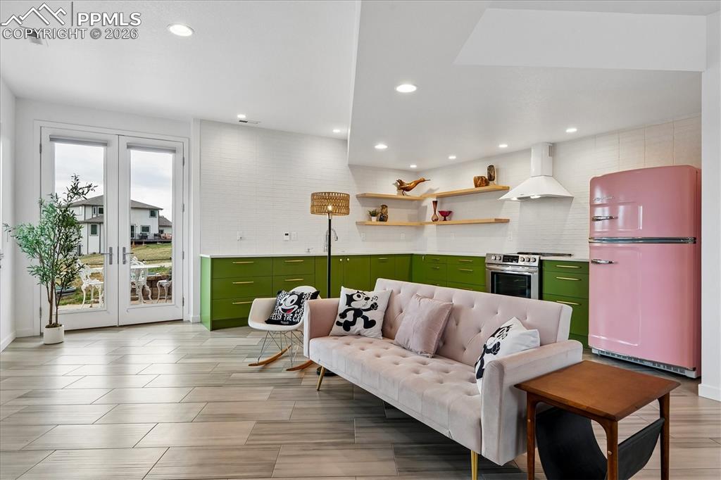 Image 39 of 50: Basement family room with heated tile flooring, open to the kitchen, with f
