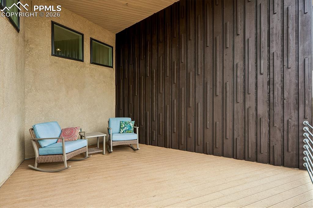 Image 9 of 50: Large front porch to the right of the front door with decorative wood panel