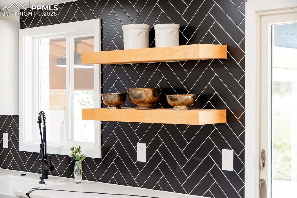 Image 10 of 43: Kitchen view of a sink and open shelves