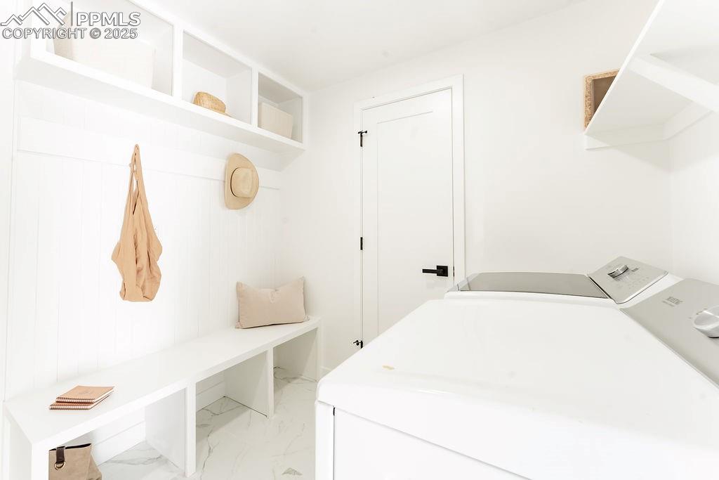 Image 22 of 43: Washroom with light marble finish floors and separate washer and dryer