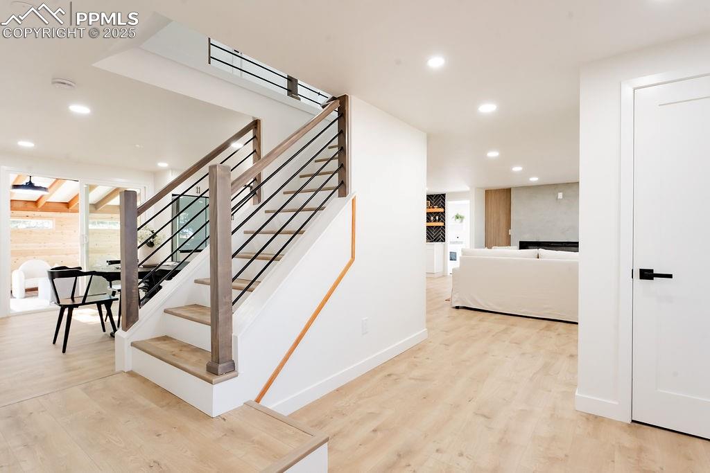 Image 23 of 43: Stairs featuring wood finished floors and recessed lighting