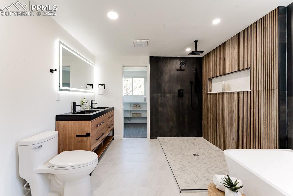 Image 28 of 43: Bathroom with wood walls, walk in shower, vanity, a freestanding bath, and 