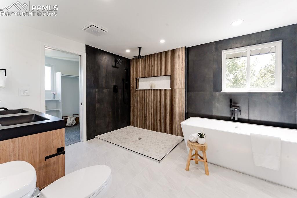 Image 29 of 43: Bathroom with a walk in shower, plenty of natural light, a freestanding tub