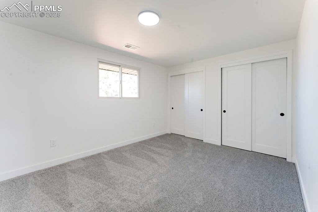 Image 31 of 43: Unfurnished bedroom featuring two closets and carpet