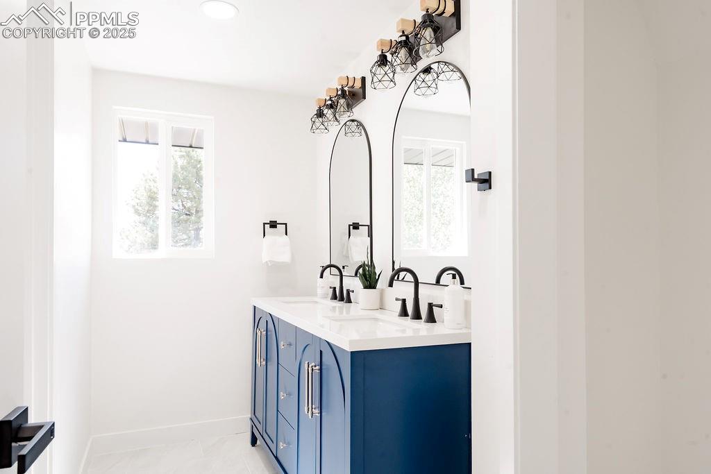 Image 32 of 43: Full bath with double vanity, recessed lighting, and light tile patterned f