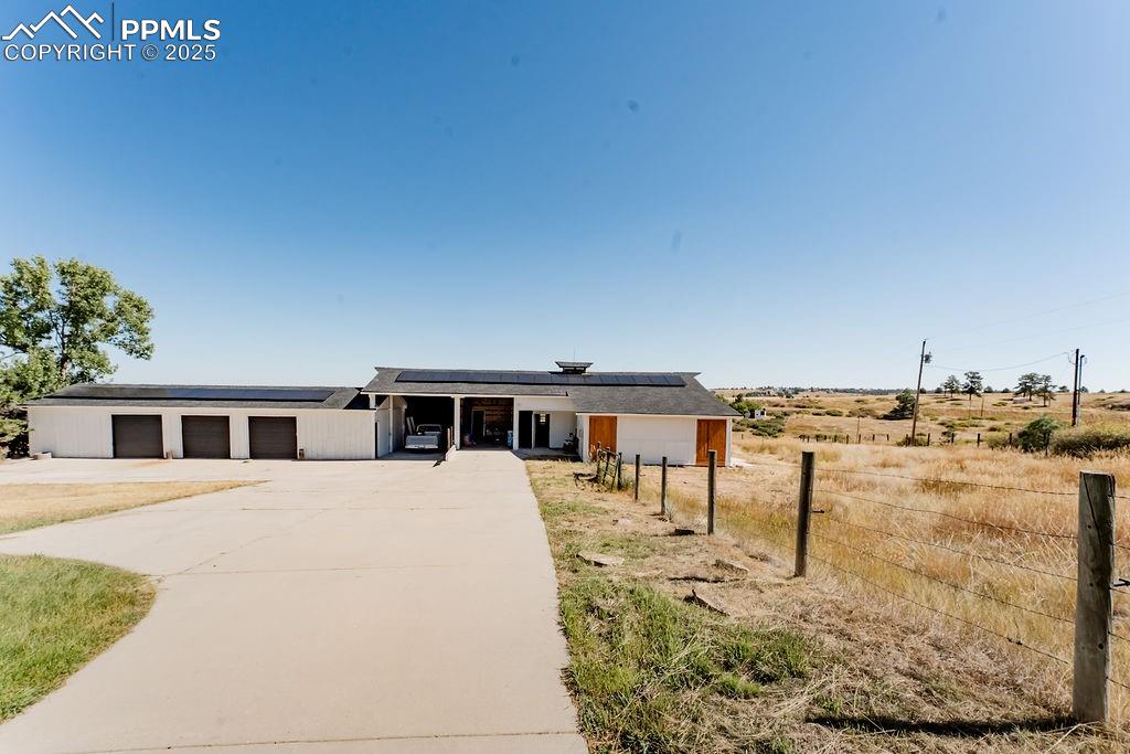 Image 40 of 43: Shop, RV parking, barn solar panels, driveway, and a porch