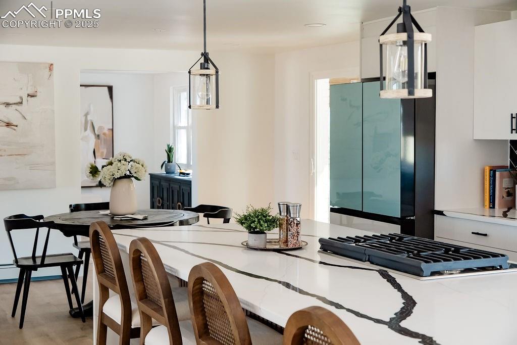 Image 5 of 43: Kitchen featuring decorative light fixtures, freestanding refrigerator, whi