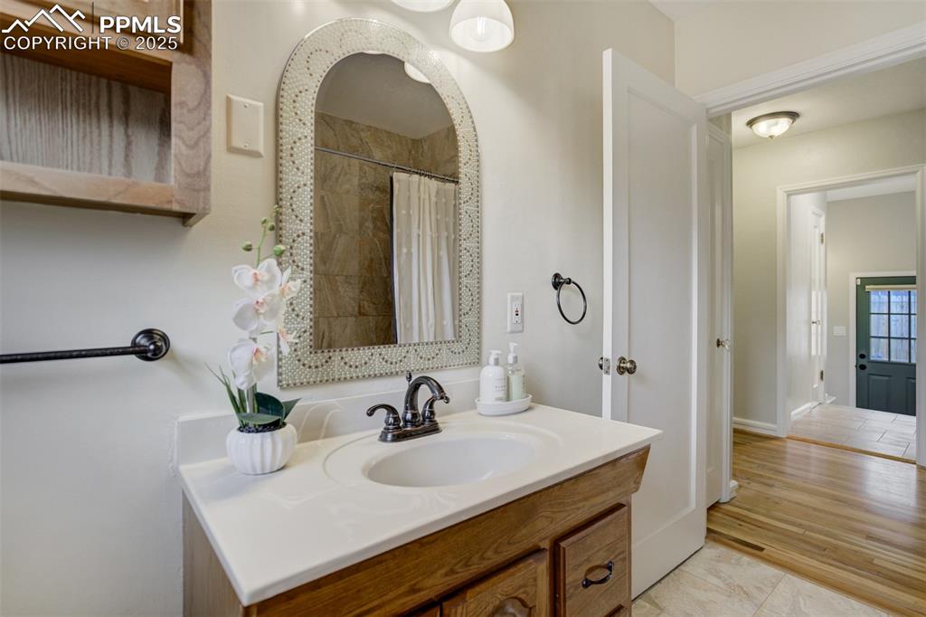Image 25 of 50: Bathroom with vanity and curtained shower