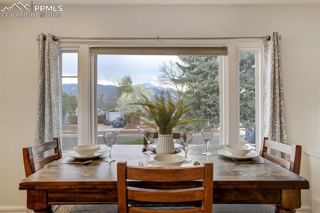Image 5 of 50: Dining space with a mountain view, baseboards, and a wealth of natural ligh