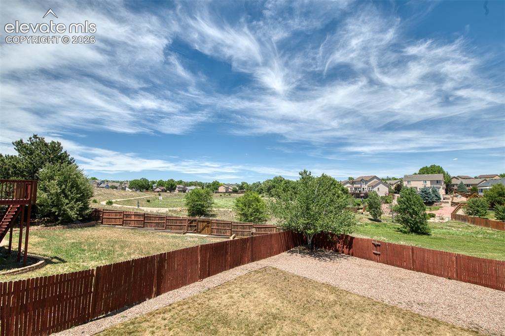 Image 16 of 46: Expansive backyard featuring a stained wood privacy fence, gravel hardscapi