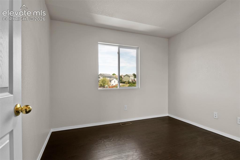 Image 22 of 46: Room featuring dark wood-finish flooring, light neutral-toned walls, and wh