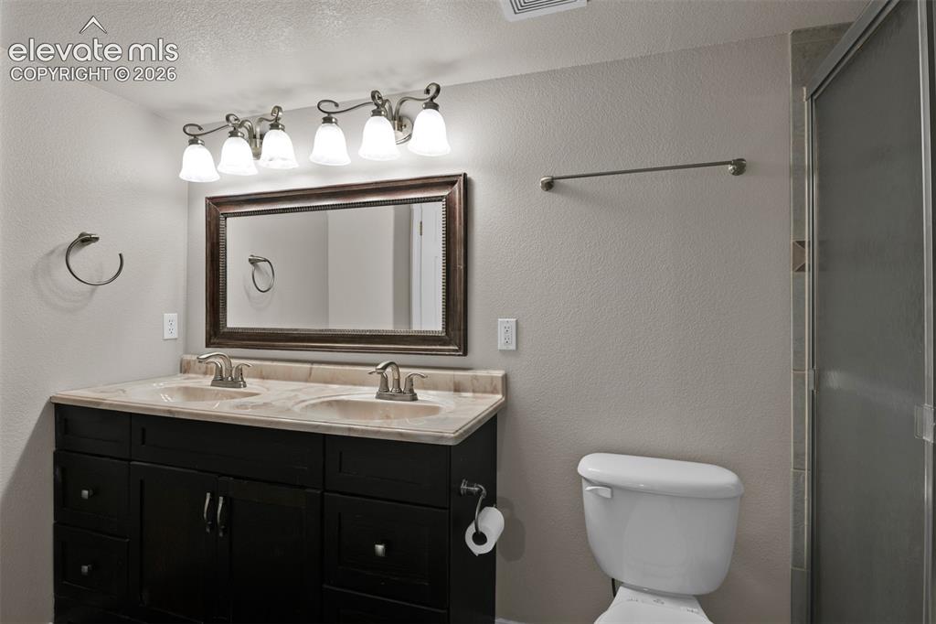 Image 34 of 46: Vanity featuring dual undermount sinks with brushed nickel fixtures, a dark