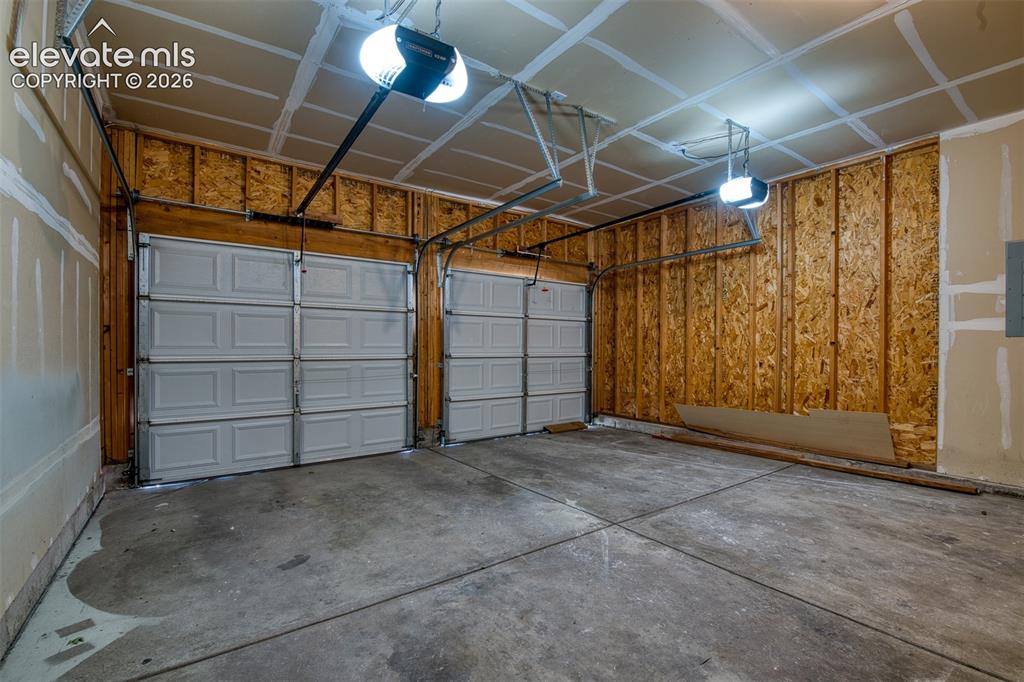 Image 43 of 46: Two-car garage featuring concrete flooring, uninsulated walls, and overhead