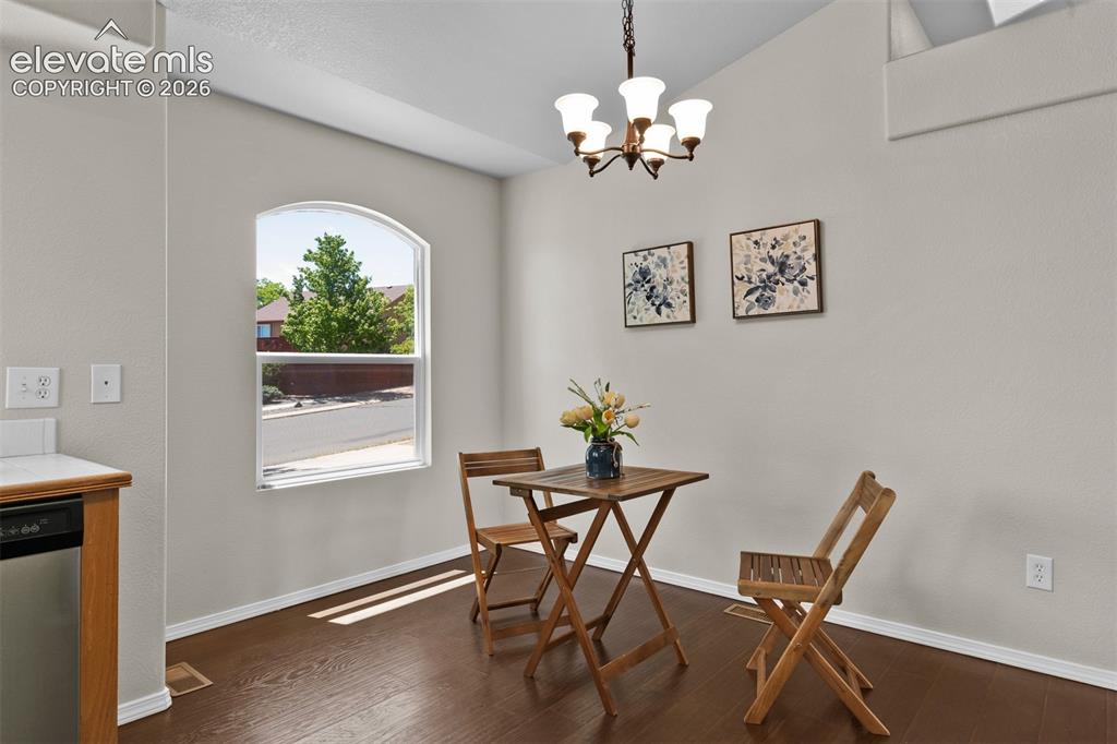 Image 8 of 46: Dining area featuring an arched window, wood-finish flooring, a contemporar