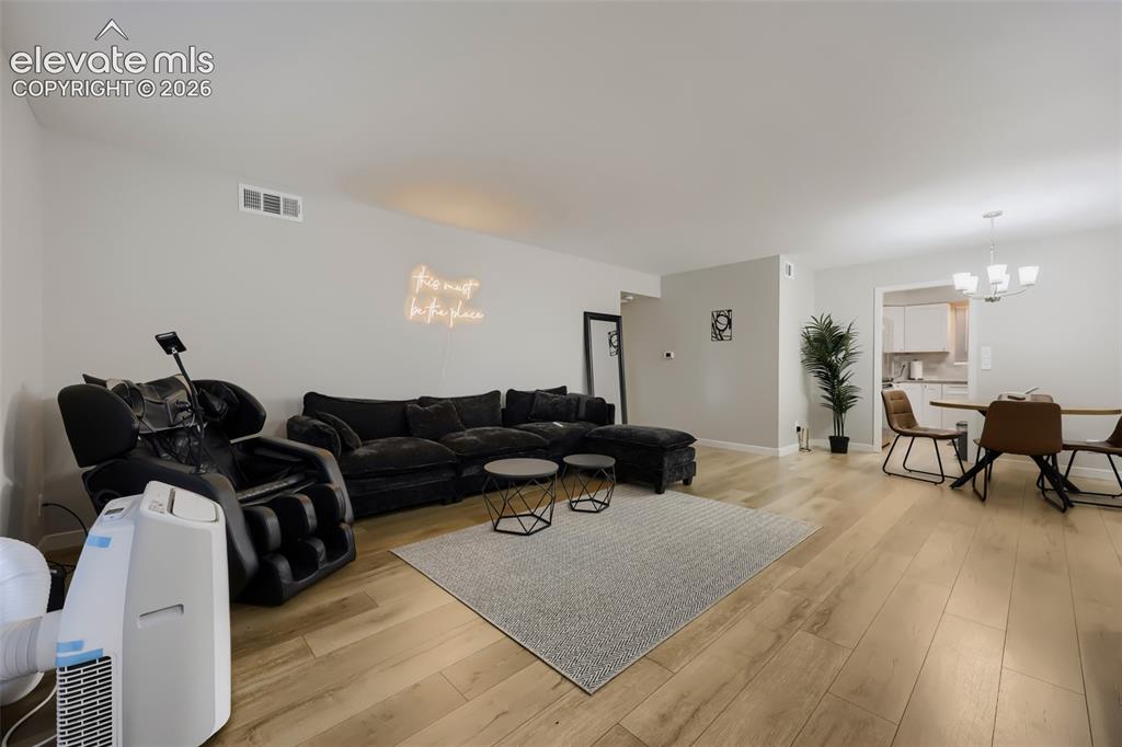 Image 13 of 28: Expansive open-concept living area featuring light wood-finish flooring, ne