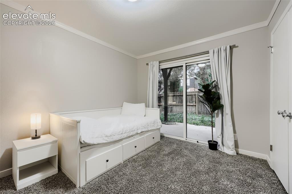 Image 21 of 28: Neutral-toned room featuring a sliding glass door with outdoor access