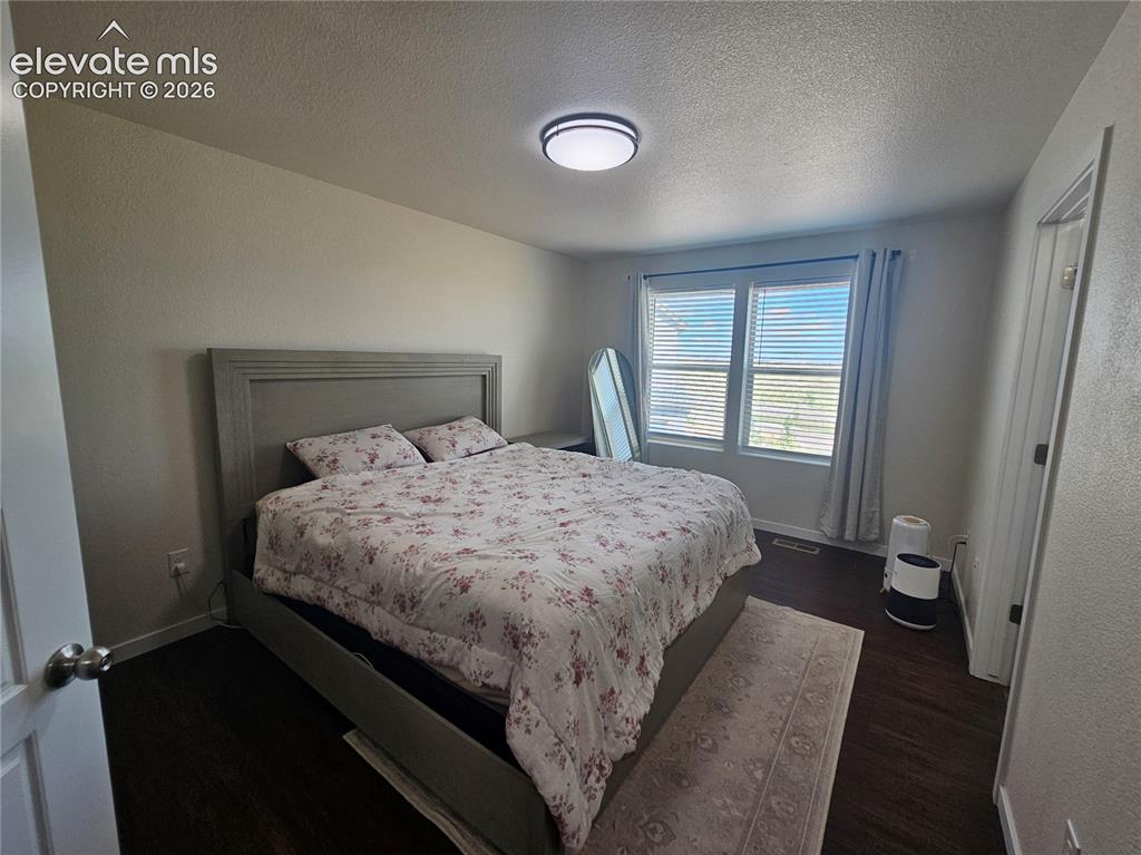 Image 13 of 23: Wood-finish flooring, light-toned walls, and a modern ceiling light fixture