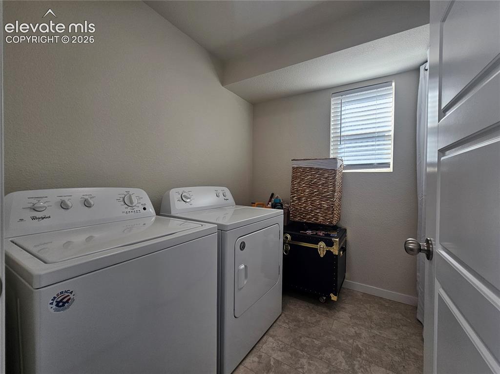 Image 19 of 23: Dedicated laundry room featuring side-by-side washer and dryer appliances,