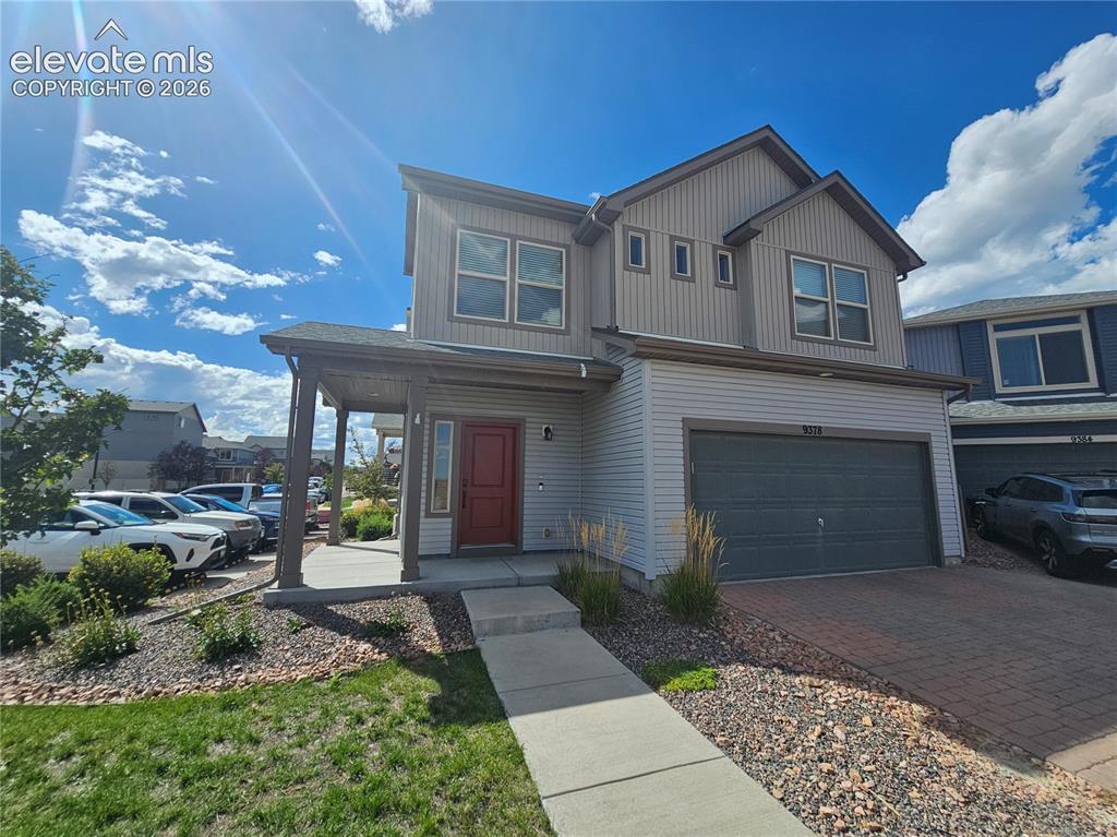 Image 2 of 23: Two-story residence featuring a covered front entry, attached garage, and a