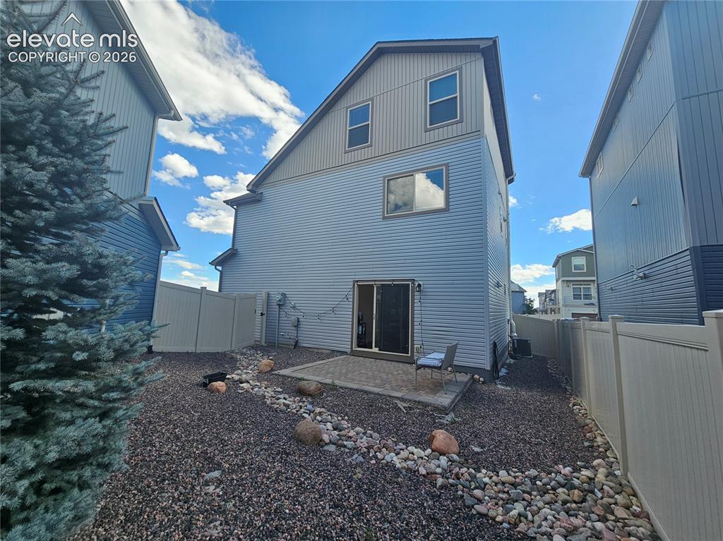 Image 23 of 23: Rear exterior featuring light blue siding, a two-story design, sliding glas
