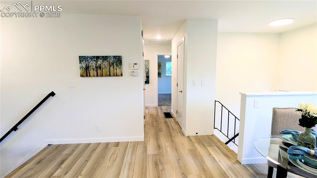 Image 13 of 39: Corridor with an upstairs landing and light wood-style flooring