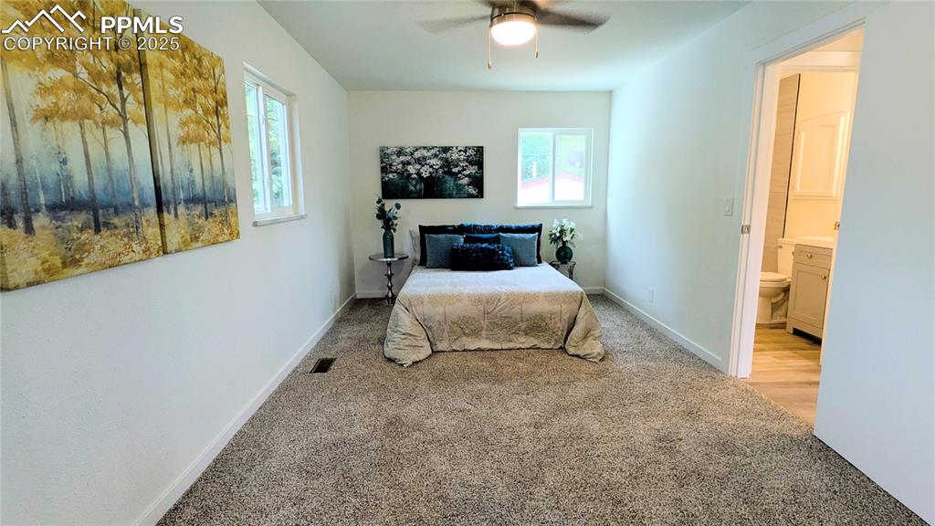 Image 14 of 39: Bedroom with light colored carpet and ceiling fan