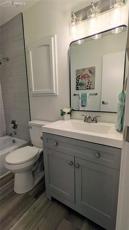 Image 18 of 39: Full bath featuring vanity, tub / shower combination, and dark wood-style f