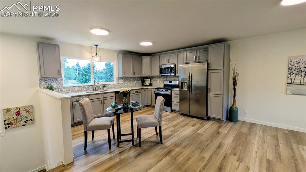 Image 2 of 39: Kitchen featuring gray cabinets, stainless steel appliances, tasteful backs