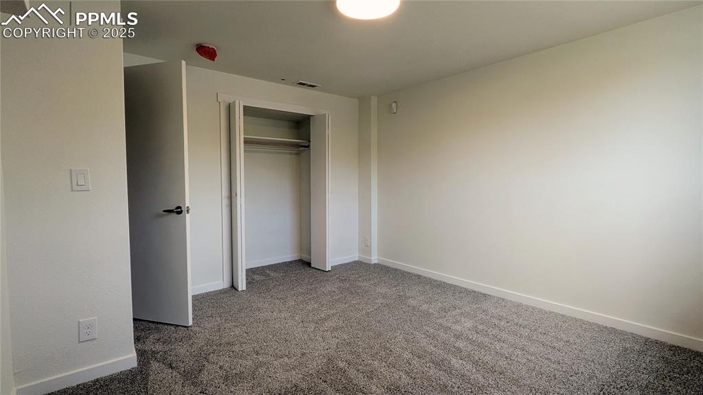 Image 27 of 39: Unfurnished bedroom with carpet flooring and a closet