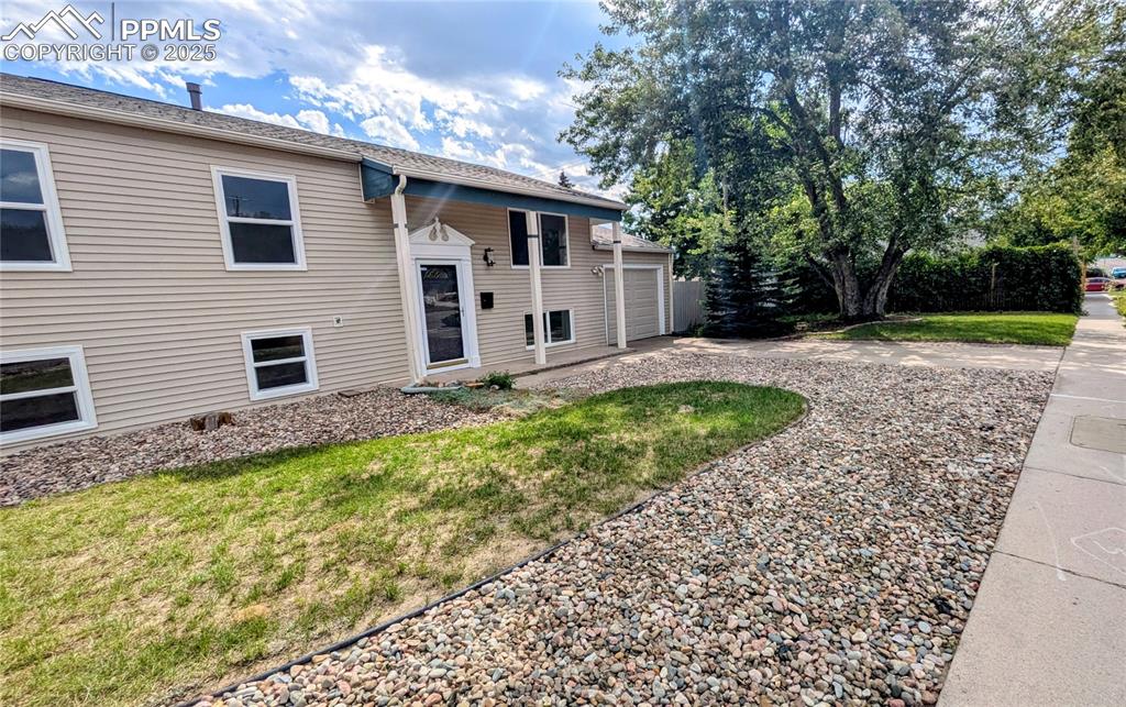 Image 7 of 39: Raised ranch featuring a front yard, driveway, and a shingled roof
