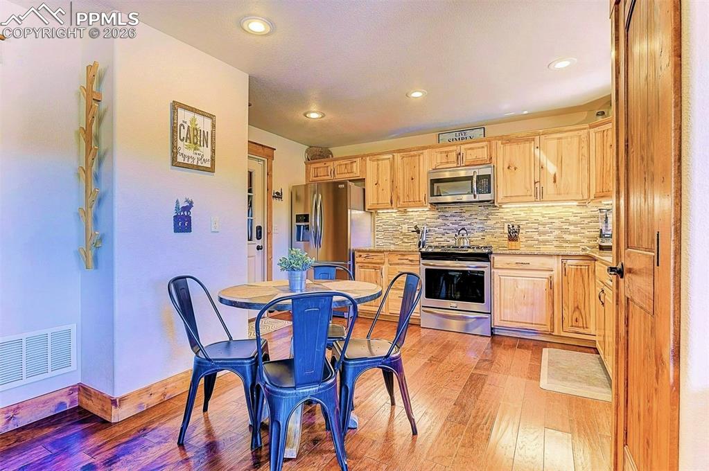 Image 8 of 28: Kitchen with appliances with stainless steel finishes, light brown cabinets