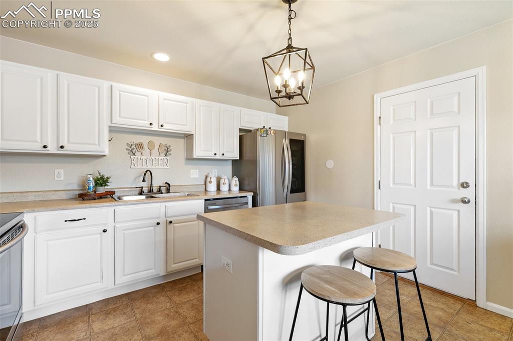 Image 11 of 27: Kitchen featuring appliances with stainless steel finishes, a kitchen islan