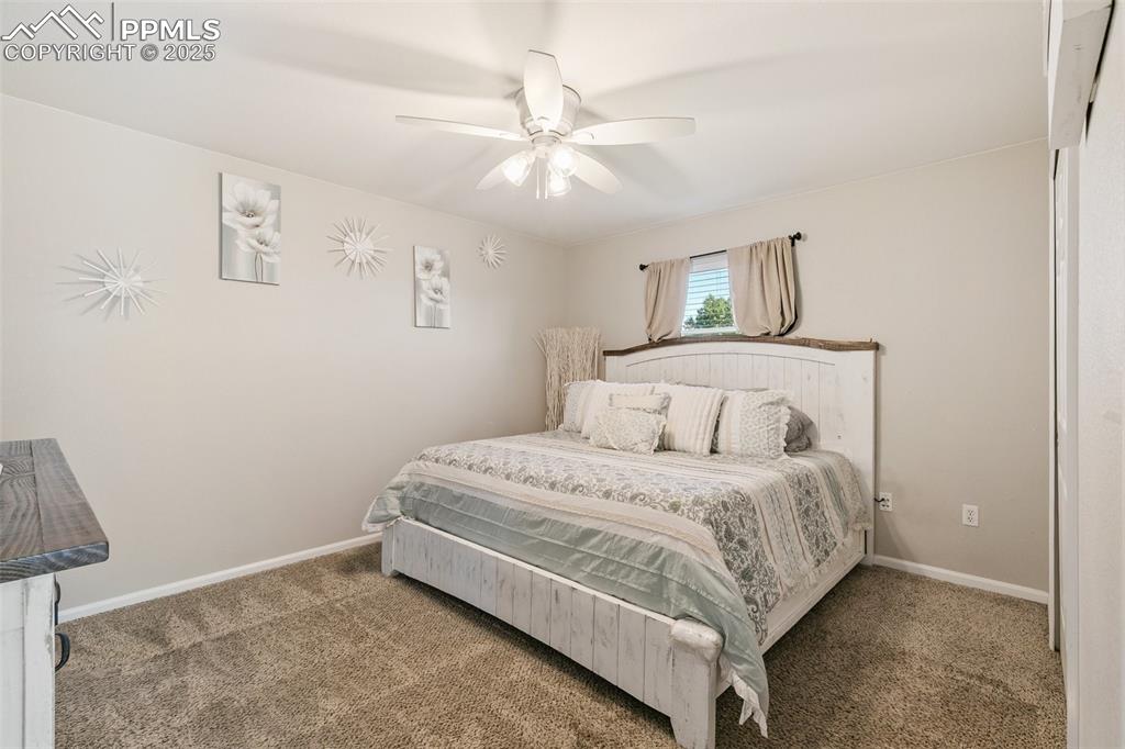 Image 13 of 27: Carpeted bedroom featuring baseboards and a ceiling fan