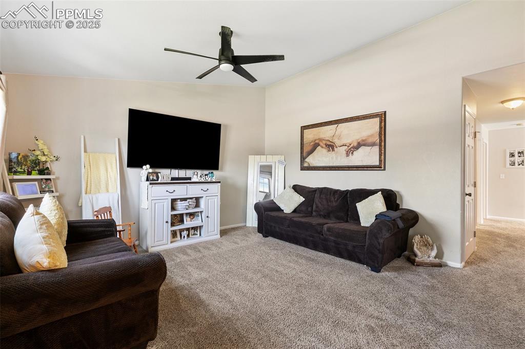 Image 3 of 27: Carpeted living area with ceiling fan and baseboards
