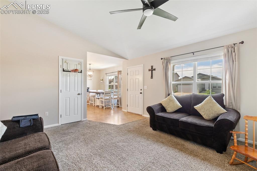 Image 6 of 27: Living room featuring ceiling fan, carpet, and vaulted ceiling
