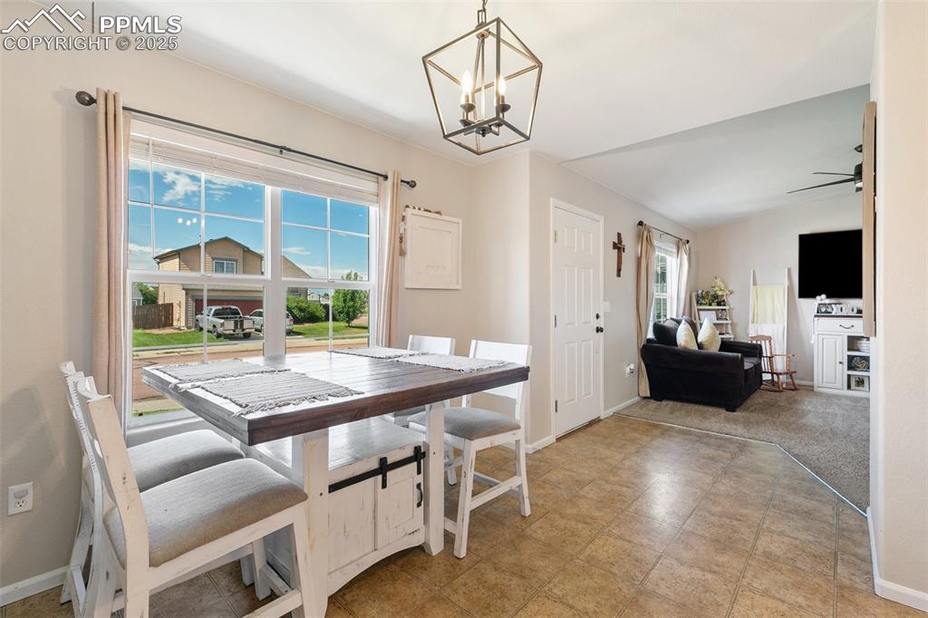 Image 9 of 27: Dining space with a chandelier and ceiling fan