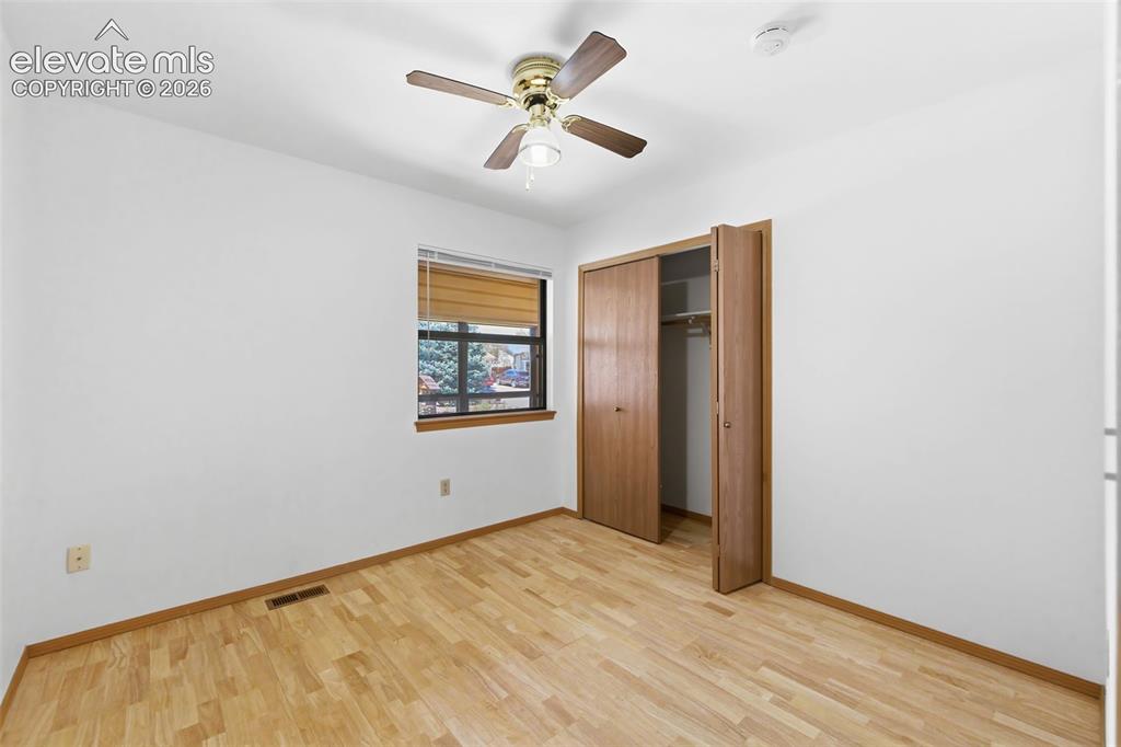 Image 13 of 29: Room featuring wood-finish flooring, a ceiling fan with integrated lighting